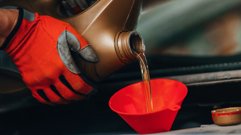 Oil pouring from a container into a funnel