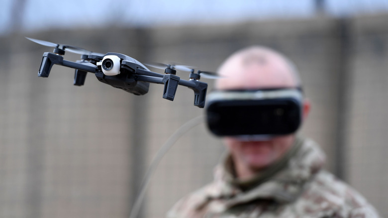 A military man flying a Parrot drone.