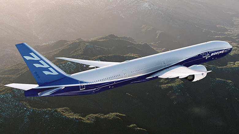 A Boeing 777 flying over mountains.