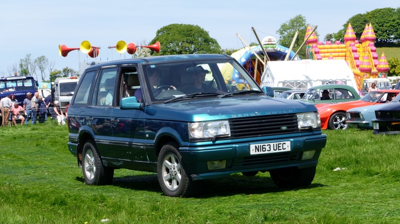 A teal colored P38A Range Rover on a field, front 3/4 view