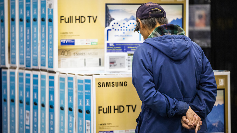 Man looking at Samsung TVs at Best Buy