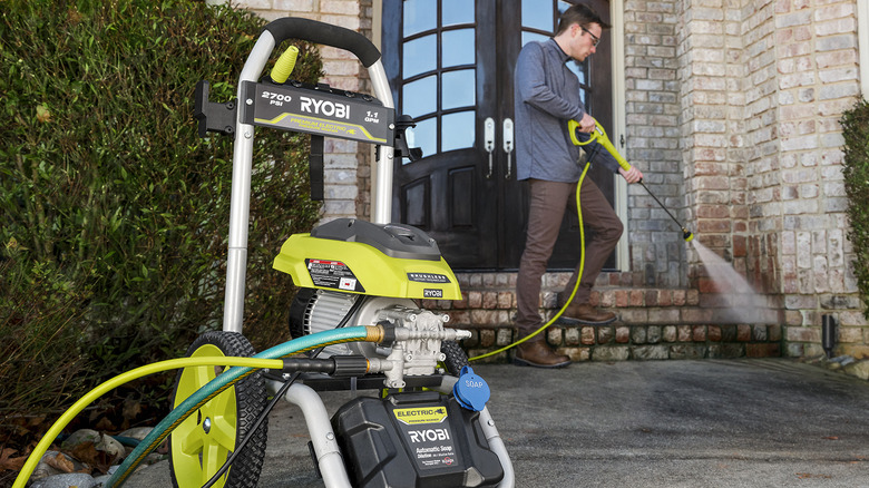 Man pressure washing stairs