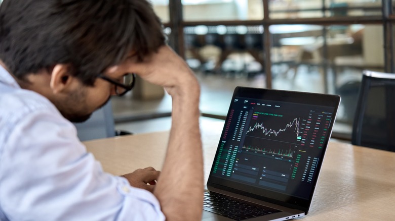 Sad cryptocurrency trader with laptop
