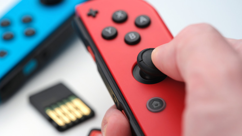 Hand holding red Nintendo Switch Joy-Con