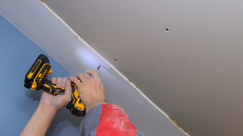 drilling holes in the ceiling