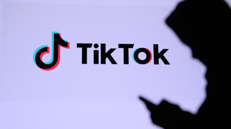 Anonymous silhouette on phone next to TikTok logo