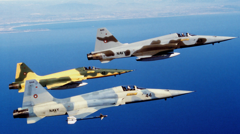 Three F-5 Tigers flying over water