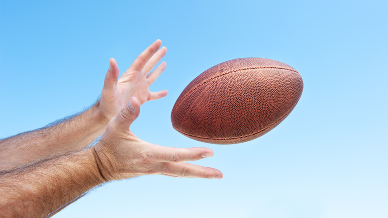 Hands reaching for a football