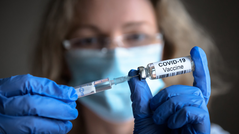 Physician holding COVID-19 vaccine dose
