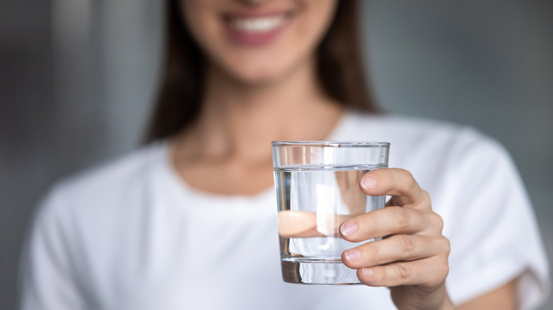 woman holding glass of water