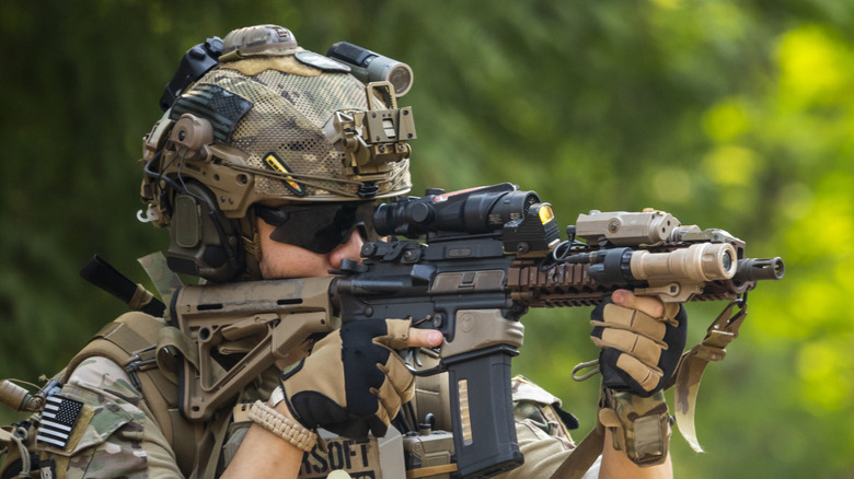 A soldier aims a rifle.