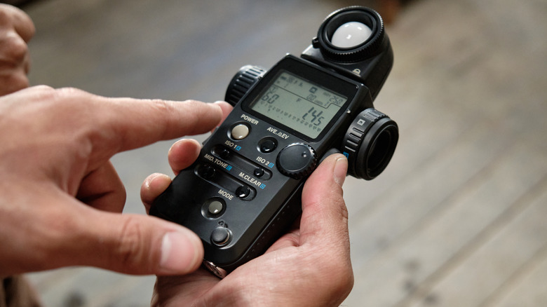 Photographer using incident light meter