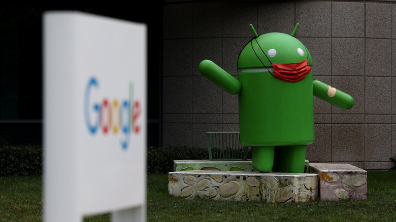 An Android statue is displayed in front of a building on the Google campus