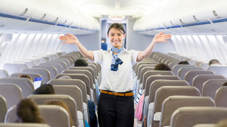 cabin crew giving safety instructions inside an aircraft