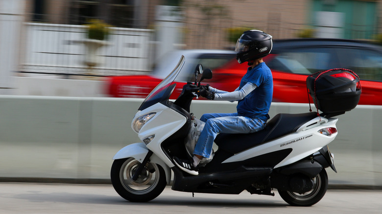 Man riding Suzuki scooter