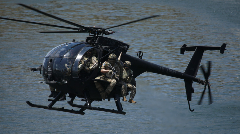 MH-6 Little Bird flying over water