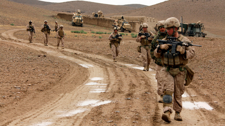 Soldiers traversing muddy fields