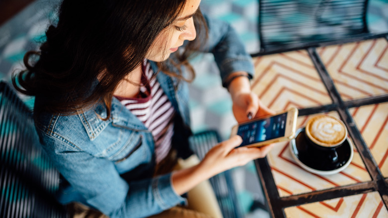 woman using phone in cafe