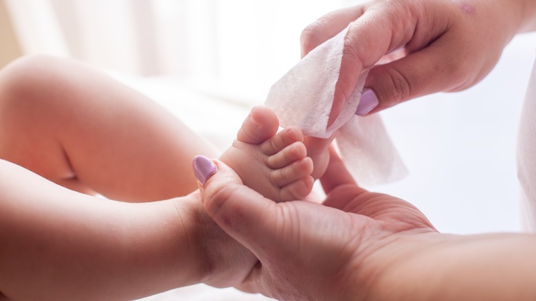 Cleaning baby's foot with wipe