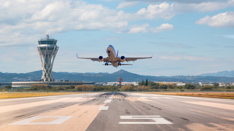 An airplane hovering above a runway.