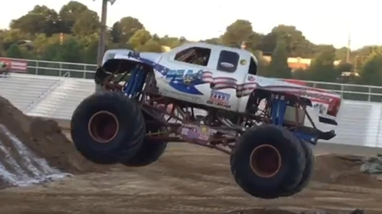 The USA-1 monster truck driving over a jump