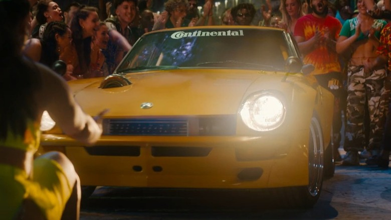 Yellow custom Datsun 240Z surrounded by people