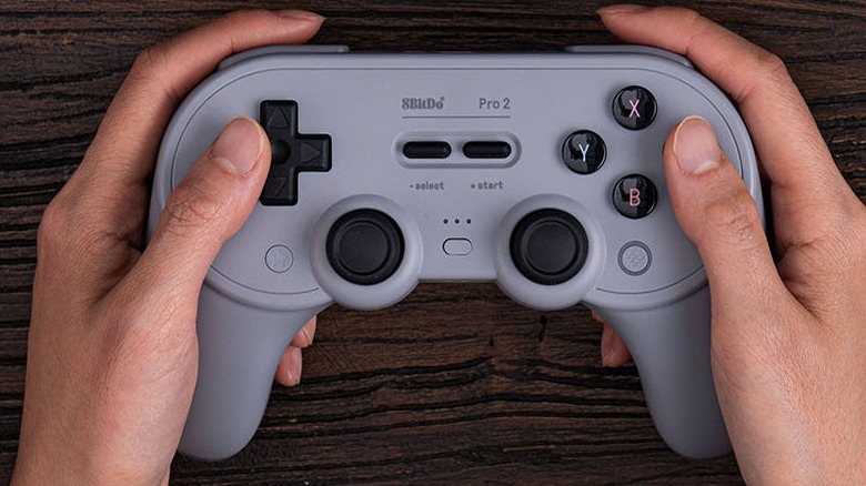 Hands holding 8BitDo Pro 2 Bluetooth Controller