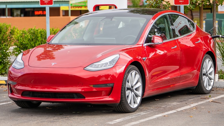 Red Tesla parked charging