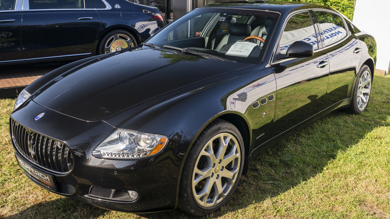 A Maserati Quattroporte sedan on a grassy field.