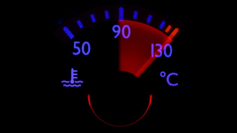 A car's dashboard thermometer with the need in the red