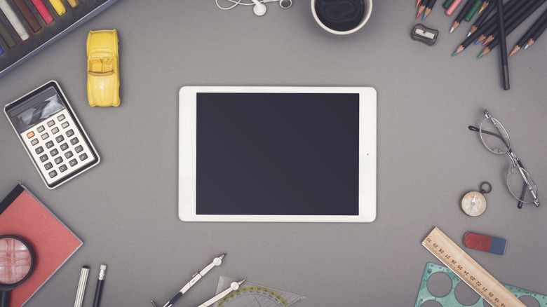 old ipad on a desk with office supplies 