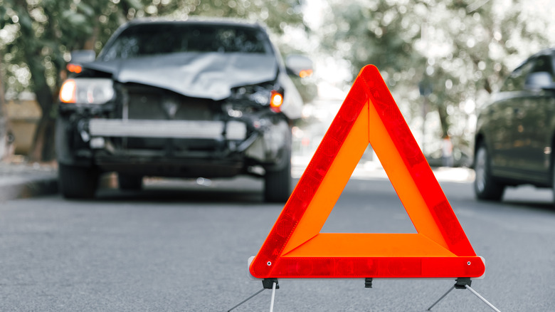 Triangle stop sign with crashed SUV