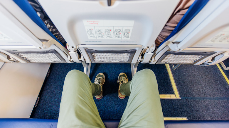 person looking at feet in airplane