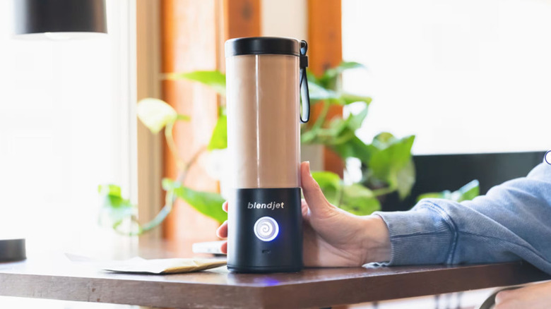 Hand holding a cup-sized blender