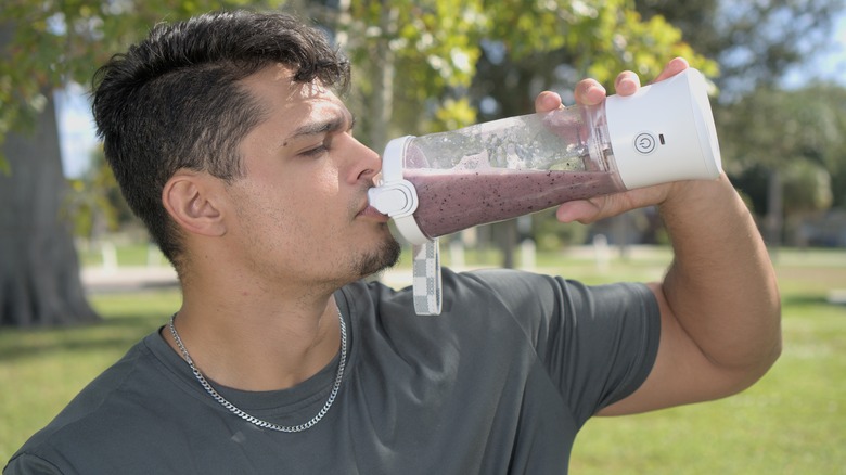 Man drinking from a personal sized blender