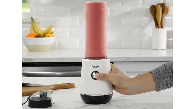 Oster brand blender with pink colored ingredients inside