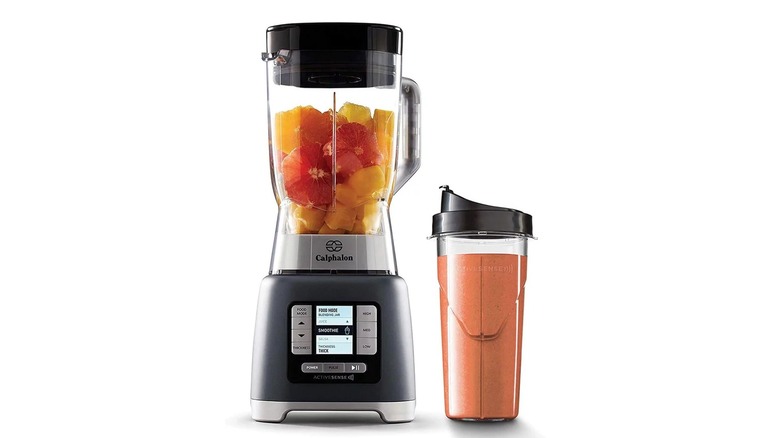 Black and clear blender with a coordinating cup containing an orange drink