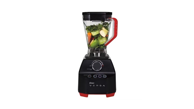 Black blender with a variety of vegetables inside the pitcher