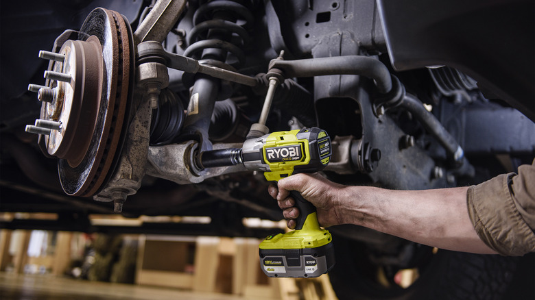 person using Ryobi impact wrench on lower strut bolt