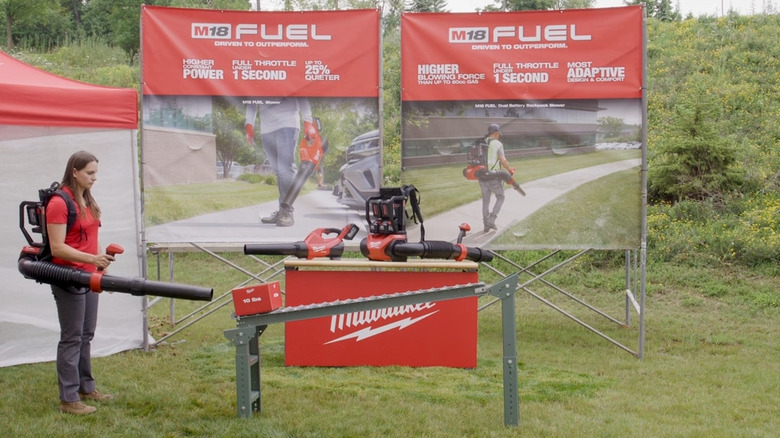 Person testing Milwaukee leaf blower on heavy box