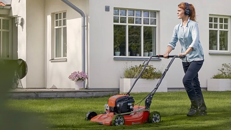 Woman pushing Husqvarna gas-powered lawn mower