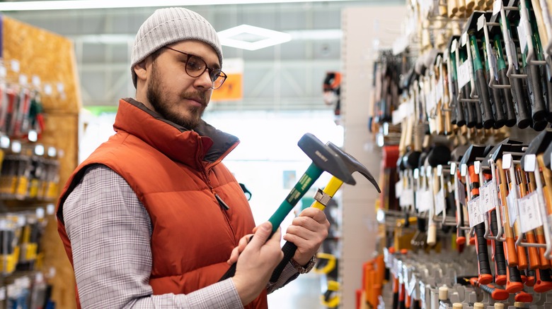 Customer deciding between two hammers