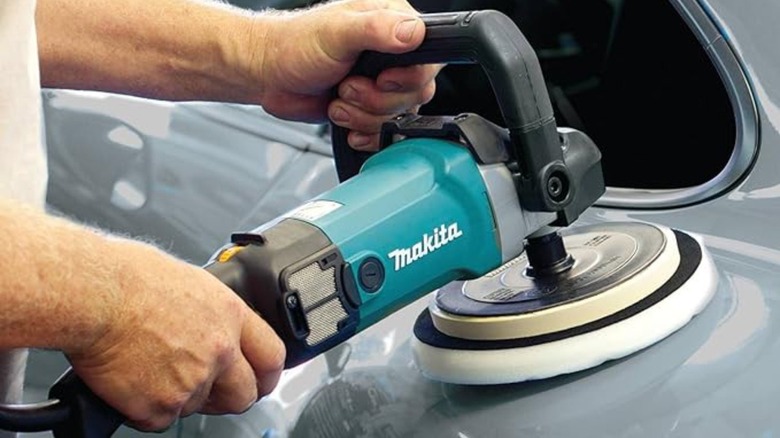 Man using Makita corded polisher on car