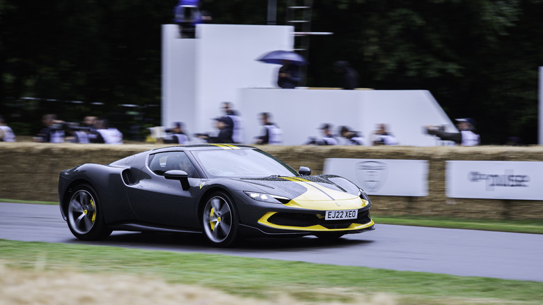 The Ferrari 296 GTB speeding through the Goodwood Hillclimb, front 3/4 view