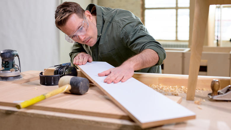 person measuring wood