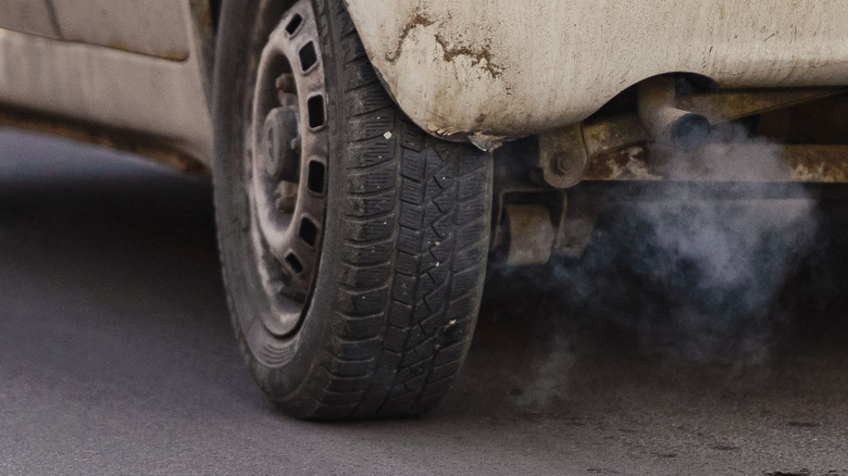 An exhaust of an old car emitting pollution-causing fumes