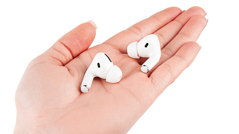 female hand holding bluetooth headphones