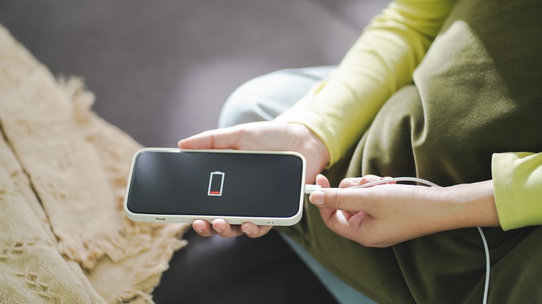 Woman plugging in iphone to charge