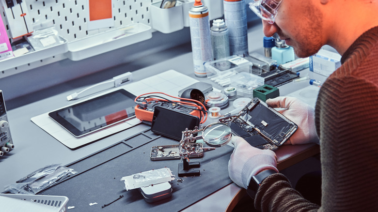 man tinkering inside an iPhone