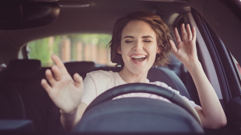 happy woman dancing in car